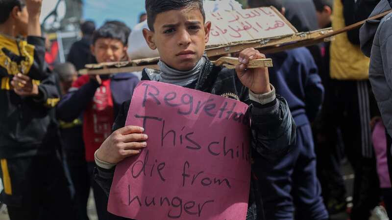 Palestinian children carry banners during a march in Rafah demanding an end to the war (Image: Getty Images)