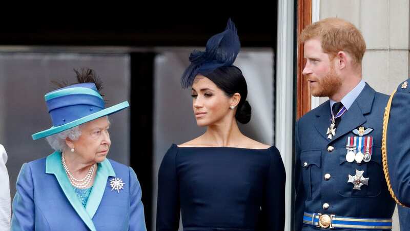 Harry and Meghan pictured with the late Queen before stepping down as royals (Image: Getty Images)