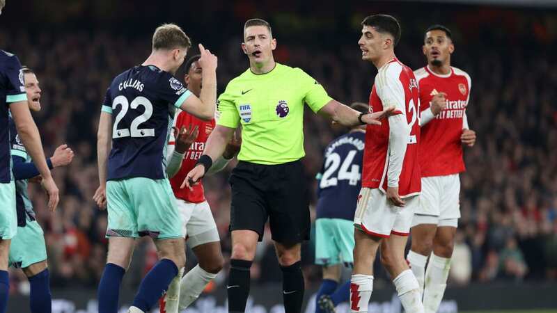 Brighton and Arsenal players are separated by referee Robert Jones