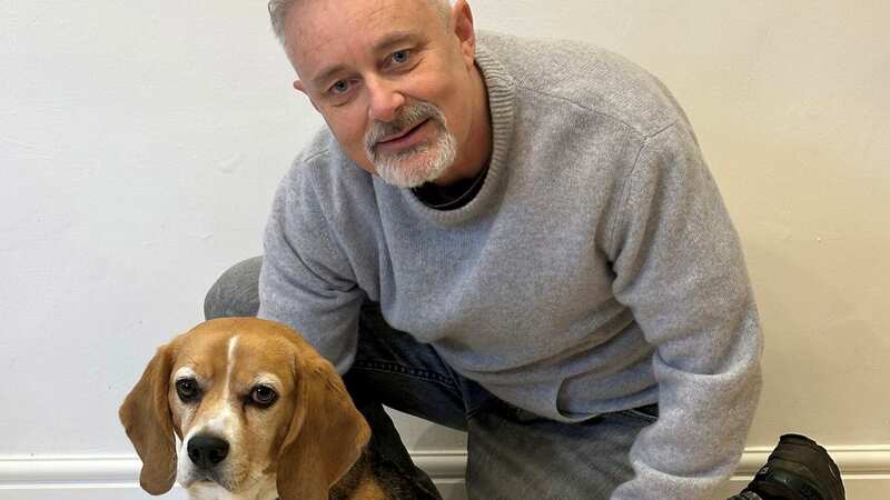 Brian Flynn with Flash the Beagle at home in Faversham, Kent (Image: Brian Flynn/SWNS)