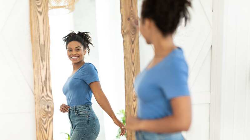 Smiling and speaking kindly to yourself in the mirror can increase positive feelings (Image: Getty Images/iStockphoto)