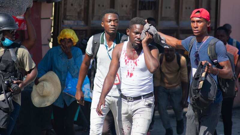 An injured journalist is helped after he was reportedly hit by police in Port-au-Prince (Image: AFP via Getty Images)