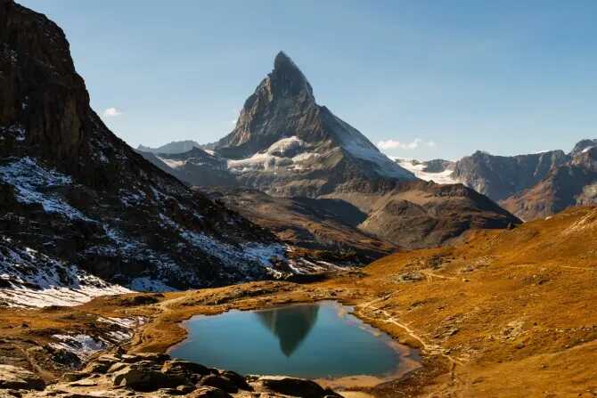 Matterhorn stands behind the Riffelsee Lake above Zermatt village in SwitzerlandCredit: Alamy