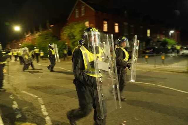 Police officers on the streets of Hartlepool following a violent protest push back against a crowd of people throwing projectiles