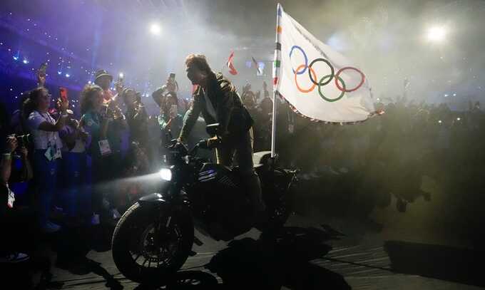 Tom Cruise made off with the Olympic flag on a motorbike after abseiling into the Stade de France. Photograph: Ashley Landis/AP