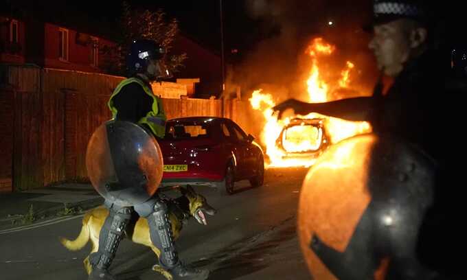 A police car burns as officers are deployed on the streets of Hartlepool after a violent disorder. Photograph: Owen Humphreys/PA