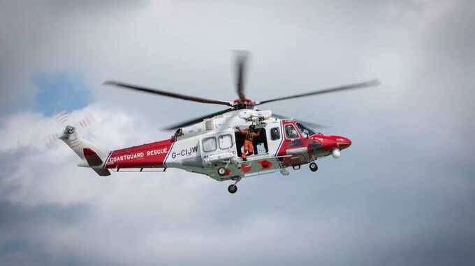 A HM Coastguard rescue helicopter hovers over water (file image) (Image: In Pictures via Getty Images)