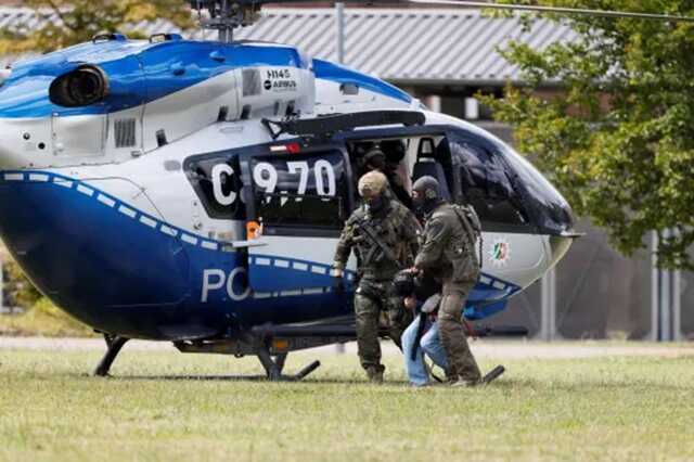 An ISIS terror suspect is forcibly removed from a police helicopter and taken away by authorities