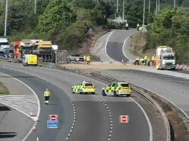 Lorry crashes through central reservation and flips over on M40