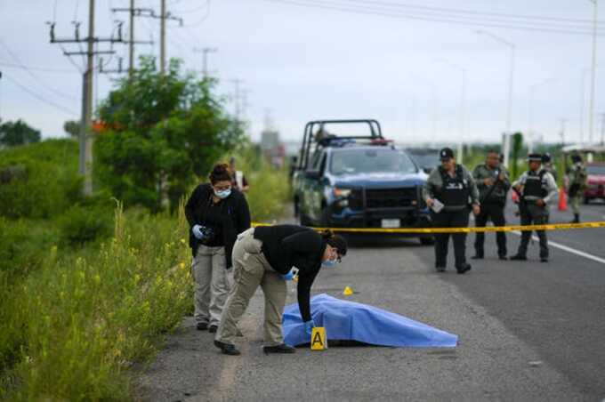 Crime scene investigators work at the site where a body was found lying on the side of a road in Culiacan, Sinaloa state, Mexico, Saturday, Sept. 21, 2024. Eduardo Verdugo / AP