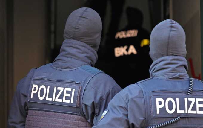 German police officers and an officer from the BKA federal police enter a house in Dresden. Photograph: Matthias Rietschel/Reuters