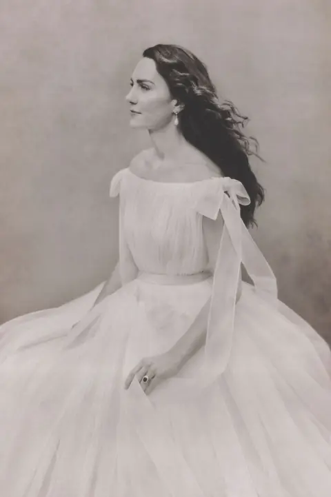 Royal Household Catherine, Princess of Wales wears a white gown and looks off to one side