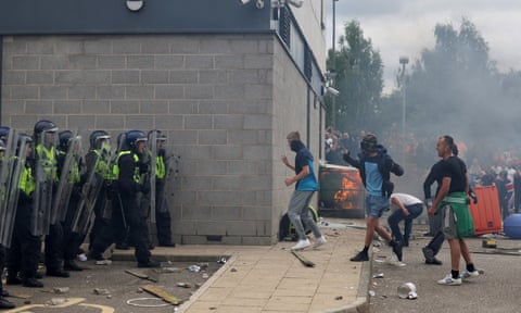 Riot police face rioters as fire burns in background qhiddziqukixkinv