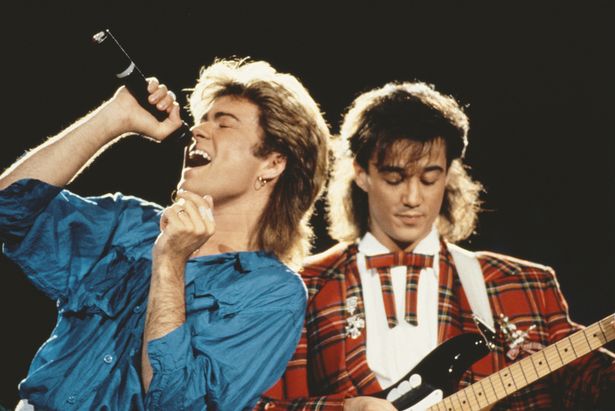 George Michael (left) and Andrew Ridgeley of Wham! performing together live on stage during the pop duo’s 1985 world tour, January 1985. ’ eiqrqidtiqdtinv