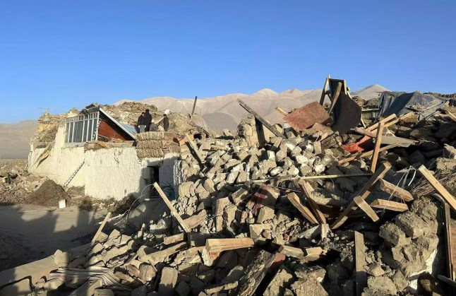 In this photo released by Xinhua News Agency, people stand amidst damaged houses in the aftermath of an earthquake in Tonglai Village, Changsuo Township of Dingri in Xigaze, southwestern China’s Tibet Autonomous Region on Tuesday, Jan. 7, 2025. (Xinhua via AP)