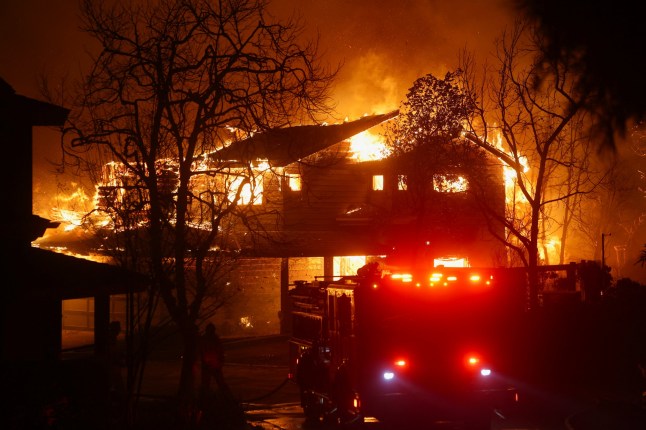 Flames rise from a structure as the Eaton Fire burns in Pasadena, California, U.S. January 7, 2025. REUTERS/Mario Anzuoni