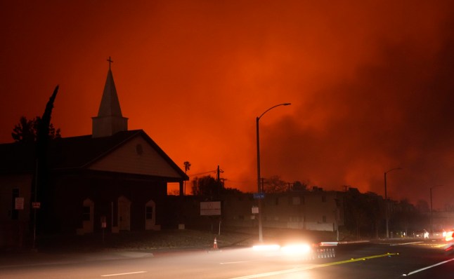 A wildfire burns in the hills near Eaton Canyon behind The Living Rock Church of Pasadena, Tuesday, Jan. 7, 2025, in Altadena, Calif. (AP Photo/Chris Pizzello)