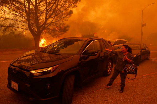 A woman cries as the Palisades Fire advances in the Pacific Palisades neighborhood of Los Angeles, Tuesday, Jan. 7, 2025. (AP Photo/Etienne Laurent)