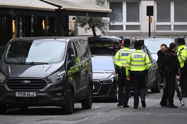 LONDON, ENGLAND - JANUARY 8: Police officers surround a suspicious car with boot raised on New Burlington Street, near Regent Street, on January 8, 2025 in London, England. Buildings along Regent Street in central London were being evacuated on Wednesday, following reports of a bomb threat in the area. (Photo by Leon Neal/Getty Images)