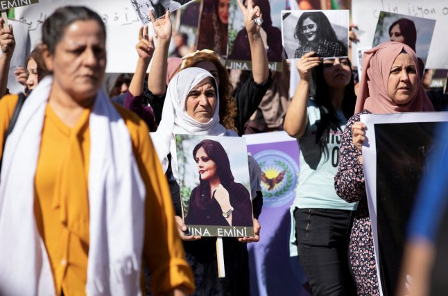 Women carry pictures during a protest over the death of 22-year-old Kurdish woman Mahsa Amini in Iran, in the Kurdish-controlled city of Qamishli, northeastern Syria September 26, 2022. REUTERS/Orhan Qereman NO RESALES. NO ARCHIVES.