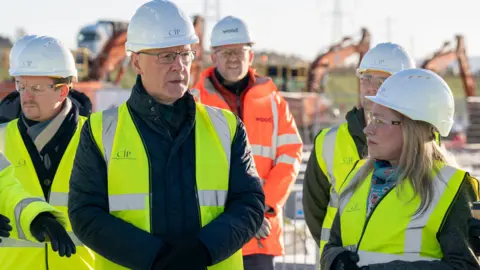 PA Media John Swinney wearing a yellow high-vis jacket and white hard hat with several similarly dressed members of the CIP team on the construction site at Coalburn 1 tdiqriqkxiqqqinv