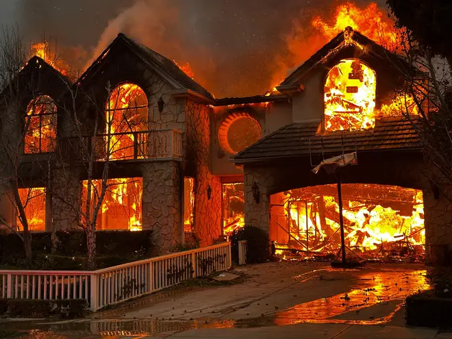 The Palisades Fire burns a structure in the Pacific Palisades neighborhood of Los Angeles, Wednesday, Jan. 8, 2025. (AP Photo/Eugene Garcia) eiqekiqkxidehinv