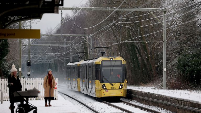 Commuters wait for a tram on a snow-covered platform in Manchester.
Pic: Reuters