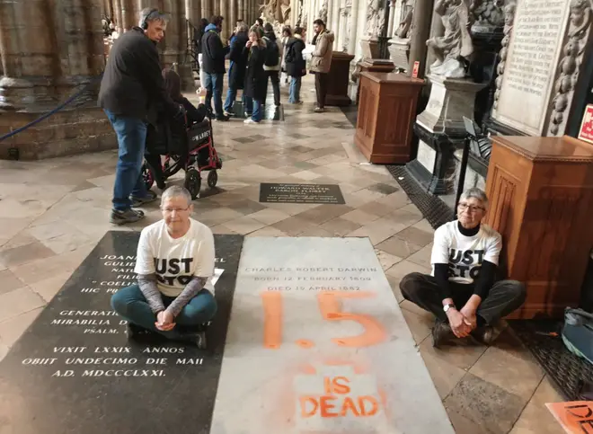 Members of the group sit by Darwin’s grave in their latest protest qhiqquiqqhidekinv