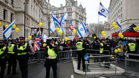 David Cliff/EPA-EFE/REX/Shutterstock Police at a protest rally with demonstrators waving flag of Israel qhiddkikuidzhinv