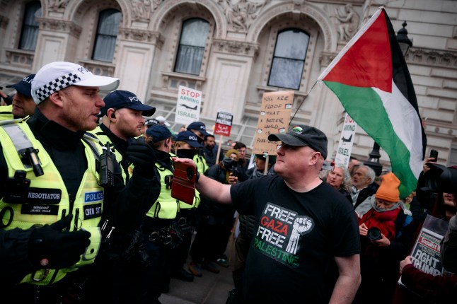 Protesters holding placards and flags face a line of police on Whitehall in central London at a National demonstration for Palestine, on January 18, 2025, organized by the Palestine Solidarity Campaign. Following the Metropolitan Police preventing a march from the BBC in London because the route passed a synagogue, protesters supporting 