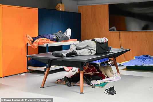  Pictures from inside the theatre show people sleeping on tables in cramped conditions