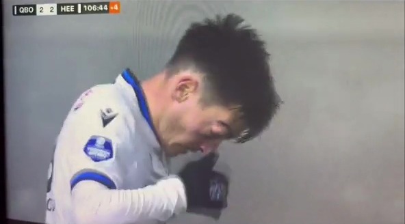 A soccer player blowing his nose during a game.