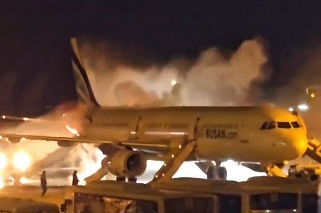 Fire authorities work to extinguish a fire that broke out on an Air Busan passenger plane at Gimhae International Airport in Busan on January 28, 2025. The tail of a passenger aircraft caught fire at an international airport in South Korea’s second-largest city on January 28, forcing the evacuation of 176 people on board, Yonhap news agency reported. (Photo by YONHAP / AFP) / - South Korea OUT / NO ARCHIVES - RESTRICTED TO SUBSCRIPTION USE (Photo by -/YONHAP/AFP via Getty Images) qhiqqkiqehiqkhinv