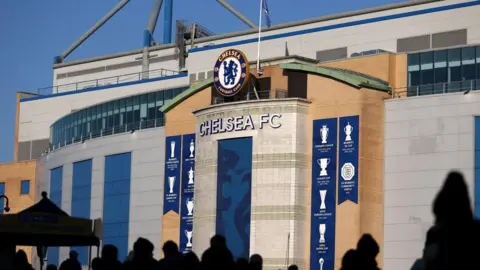 Getty Images The exterior of Stamford Bridge,  Chelsea FC’s stadium, with a giant version of the club’s crest on display, along with banners celebrating the trophies it has won.