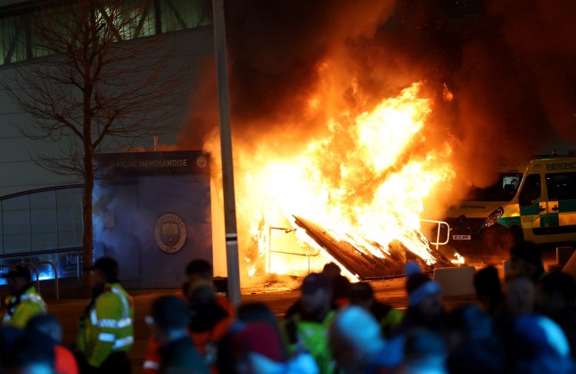 MANCHESTER, ENGLAND - JANUARY 29: A general view as a merchandise stall on the outside of the stadium is seen on fire as fans gather outside the stadium prior to the UEFA Champions League 2024/25 League Phase MD8 match between Manchester City and Club Brugge KV at City of Manchester Stadium on January 29, 2025 in Manchester, England. (Photo by Carl Recine/Getty Images) eiqeeiqdridrkinv