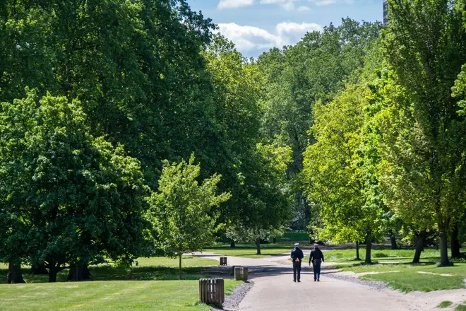 UK, England, London, Westminster, Green Park. Two police constables walking on a path through an empty Green Park, next to Buckingham Palace eiqrriqhzihhinv