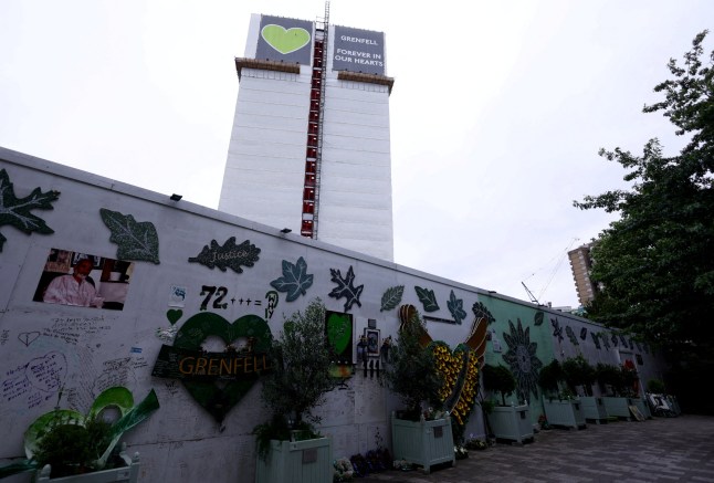 FILE PHOTO: The covered remains of Grenfell Tower are seen behind a wall of condolences, ahead of the publishing of the second report of the UK public inquiry into the deadly 2017 Grenfell fire, in London, Britain, August 22, 2024. REUTERS/Hannah McKay/File Photo