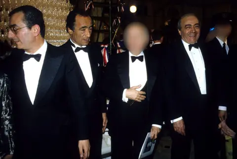 Shutterstock Ali with his brothers Salah and Mohamed (L-R). They are all dressed in black tie and Mohamed is smiling broadly at the camera.  
 eiqeeiqduiqquinv