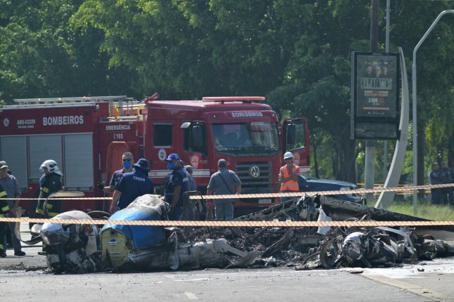 Members of Brazil’s Aviation Accident Investigation and Prevention Center (CENIPA) and firefighters work at the site of a plane accident in Sao Paulo, Brazil, on February 7, 2025. A plane plunged into a major avenue in the Brazilian city of Sao Paulo on Friday and exploded after hitting a bus, leaving two people dead and six injured, officials said. (Photo by NELSON ALMEIDA / AFP) (Photo by NELSON ALMEIDA/AFP via Getty Images)