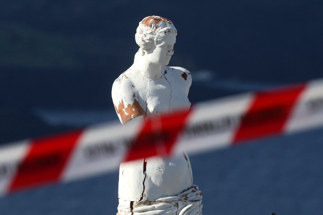 epa11878648 A statue sits inside a police cordoned-off area, one of the dangerous spots on the volcanic caldera in the almost evacuated village of Fira in Santorini, Greece, 06 February 2025. The municipality of Thera (Santorini) advised the emptying of water from swimming pools, banned all construction work and forbade access to the Athinio port, except when ships are docking, due to a wave of seismic activity. More than ten earthquakes of over 4.0 magnitude have jolted the region since the night of February 4. EPA/ORESTIS PANAGIOTOU