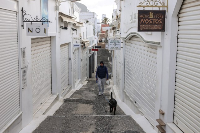 A resident walks his dog in the village of Fira, as the increased seismic activity continues on the island of Santorini, Greece, February 7, 2025. REUTERS/Louisa Gouliamaki