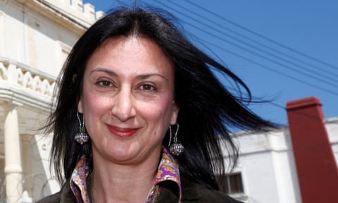 Closeup of Galizia smiling with white building behind and blue sky