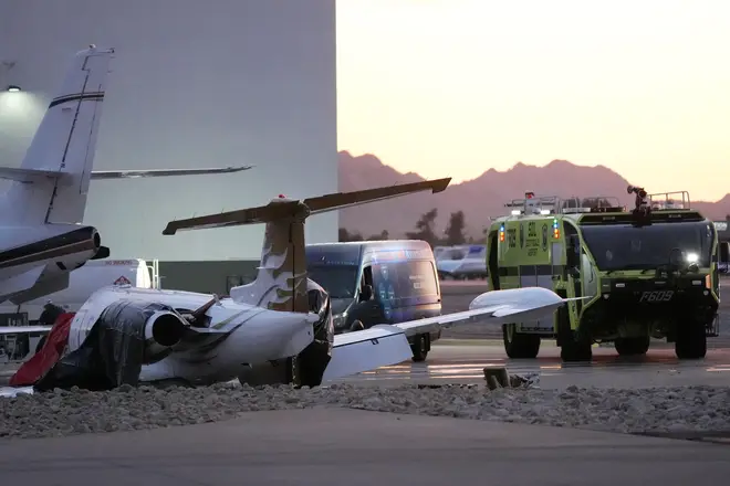 A crashed Learjet sits next to a plane it collided with as Scottsdale Airport qhiquqiqetieuinv