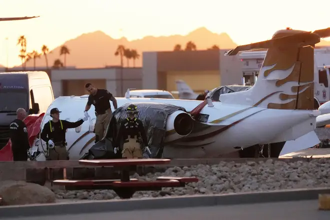 Scottsdale Fire Department firefighters work on a crashed Learjet at Scottsdale Airport.