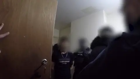 National Crime Agency Body worn footage of a man being arrested. He has several police officers around him and all faces are blurred tidttiqzqiqkdinv eiqrkidztiezprw