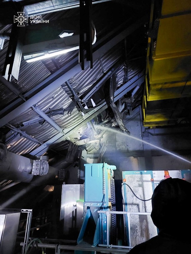 Firefighters work under the New Safe Confinement (NSC) structure that covers the old sarcophagus which confines the remains of the damaged fourth reactor, hit by a Russian drone strike, amid Russia’s attack on Ukraine, at the Chornobyl Nuclear Power Plant, in Kyiv region, Ukraine February 14, 2025. Press service of the State Emergency Service of Ukraine/Handout via REUTERS ATTENTION EDITORS - THIS IMAGE HAS BEEN SUPPLIED BY A THIRD PARTY. DO NOT OBSCURE LOGO.