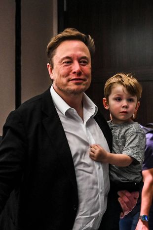 Twitter CEO Elon Musk holds one of his children after a keynote speech at the "Twitter 2.0: From Conversations to Partnerships," marketing conference in Miami Beach, Florida, on April 18, 2023. (Photo by CHANDAN KHANNA / AFP) (Photo by CHANDAN KHANNA/AFP via Getty Images)