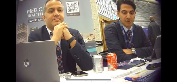 Two men in suits sat over the table from Mirror reporters