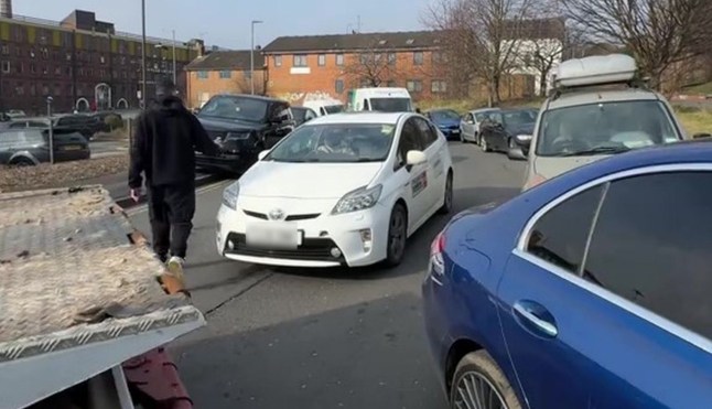 PIC FROM KENNEDY NEWS AND MEDIA (PICTURED: ROB KELLY, 31, OUTSIDE VERTU LAND ROVER LEEDS THE DAY HE BLOCKED THE ROAD) A furious Land Rover driver BLOCKED a dealership in a six-hour stand-off - after being refused warranty repairs on ?120,000 motor. Rob Kelly abandoned his lorry in the road outside Vertu Land Rover Leeds in Leeds, West Yorkshire, on February 18th and refused to shift it until free engine repairs were done to his car. The 31-year-old claims he’d been in touch with the dealership a number of times after his 2022 Urban Defender broke down in January. DISCLAIMER: While Kennedy News and Media uses its best endeavours to establish the copyright and authenticity of all pictures supplied, it accepts no liability for any damage, loss or legal action caused by the use of images supplied and the publication of images is solely at your discretion. SEE KENNEDY NEWS COPY - 0161 697 4266 tdiqriqxqikkinv