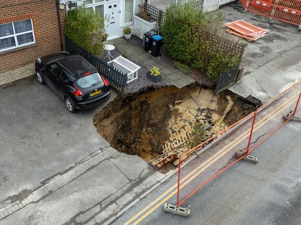 The sinkhole appeared in Godstone High Street in Surrey on Monday night and grew to 20m long by the following lunchtime